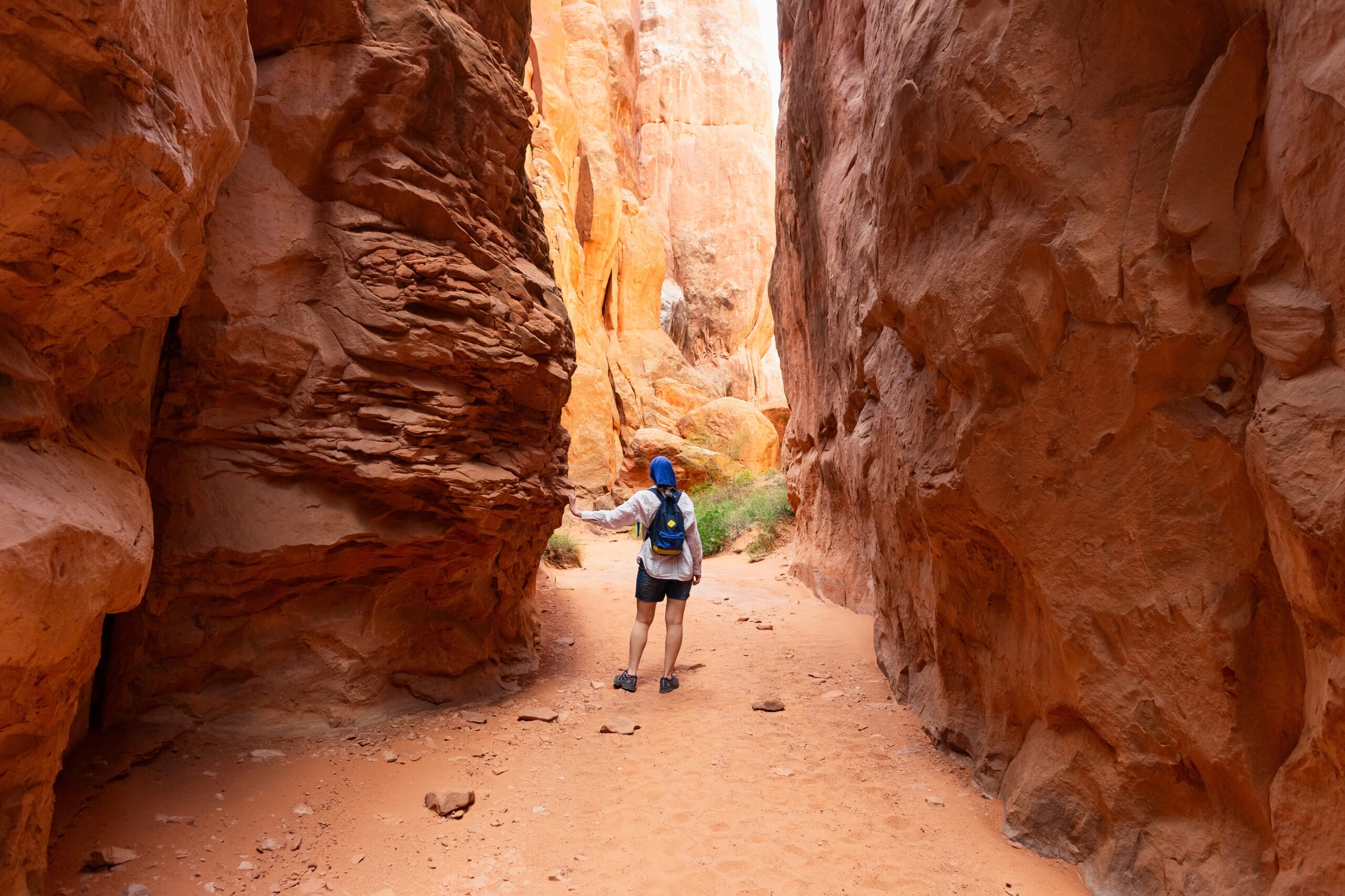 WomanTravelingThroughNarrowSandstoneDesertRockCanyonHikingTrail | I Heart RVing
