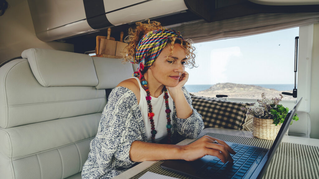 AttractiveYoungAdultWomanUsingLaptopComputerInsideCamperVan | I Heart RVing