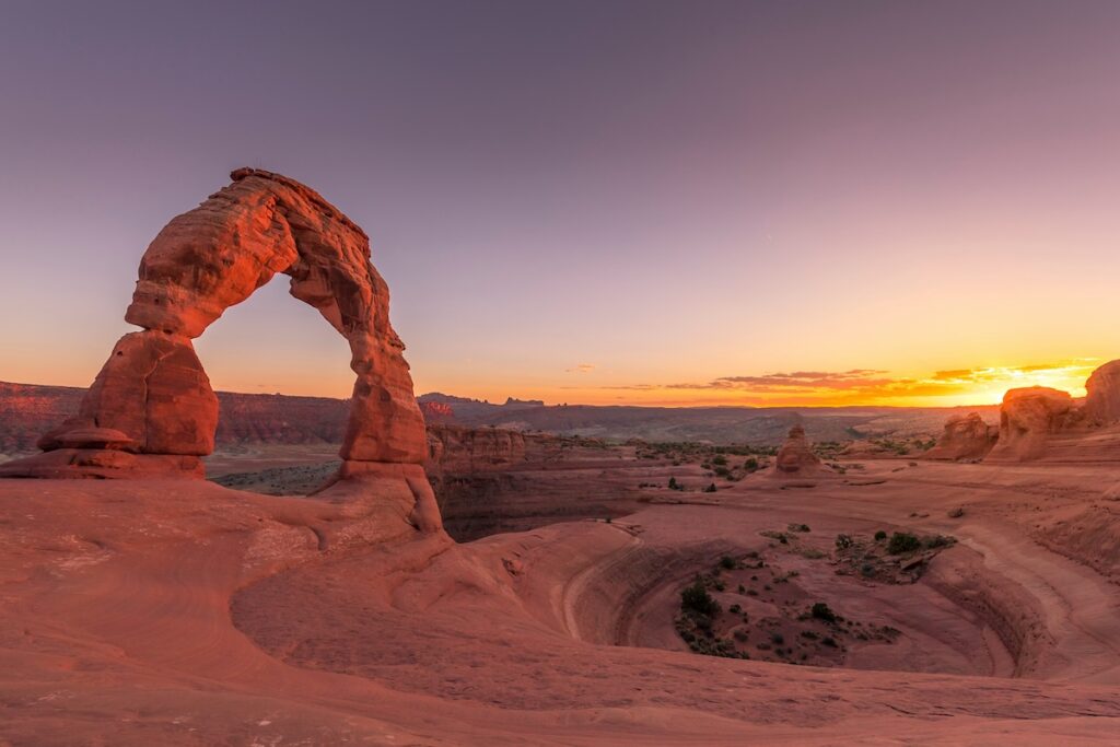 ken-cheung-Lxz4-F6HfUo-unsplash | I Heart RVing Delicate Arch sandstone formation at sunset in a desert canyon with warm orange light on red rocks.