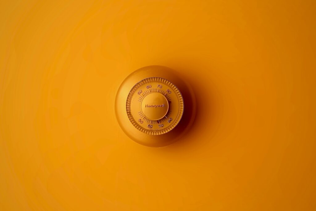 Close-up of a circular brass Honeywell combination lock dial centered on an orange background
